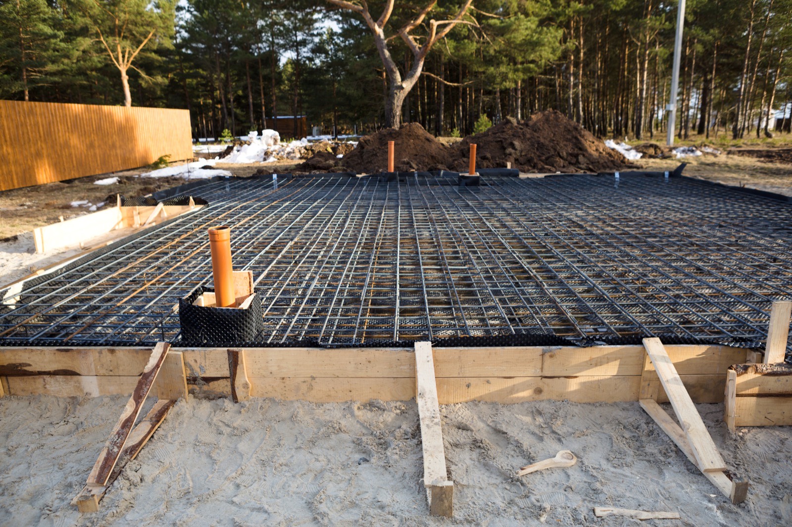 Lemezalap a betonozás előtt. A narancssárga csövek nem véletlenül állnak ki: a gépészeti kiállásokat a fogadószerkezeti beton elkészülte előtt kell megszerelni — utólag már csak bontással lehet.